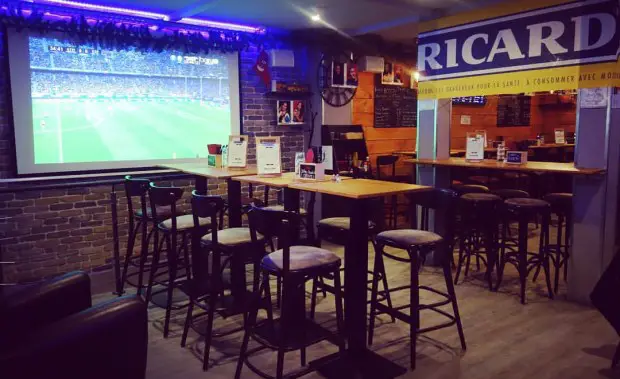 La sala del bar con un pantalla para el futbol