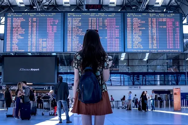 fille devant le tableau aéroport 